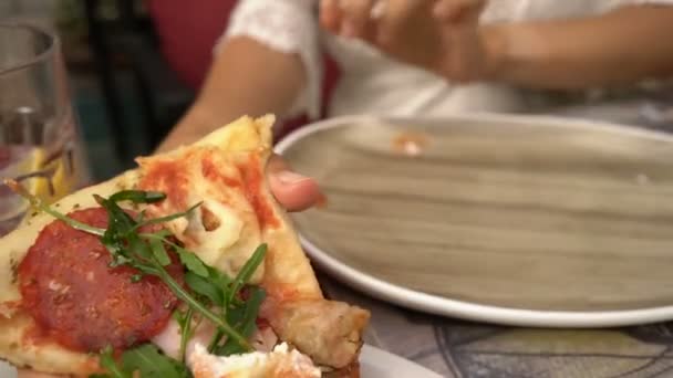 Jonge vrouw die pizza eet in een café — Stockvideo