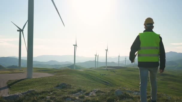 Tecnico Ingegnere nella centrale eolica a turbina in piedi con un tablet in mano — Video Stock