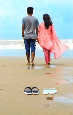 Genç çift sahilde birlikte vakit geçiriyor. Sahilde romantik yeni evli çiftler. Cox 's Bazar / 2020.