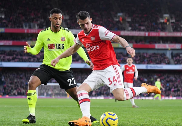 LONDON, ENGLAND - 18 Ocak 2020: Sheffield 'den Lys Mousset ve Arsenal' den Granit Xhaka, Arsenal FC ile Sheffield United arasında oynanan 2019 / 20 Premier League maçı sırasında çekilmiştir..