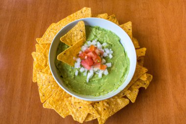 Masanın üzerinde nacho soslu ev yapımı guacamole sosu.