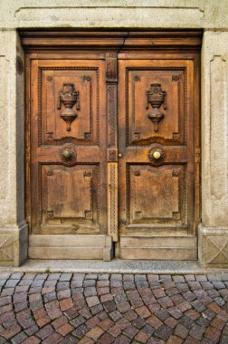 ancient wooden door with handle and decorations of a historic building clipart