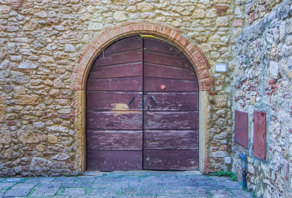 ancient door with arch, in wood consumed by the use of historical building