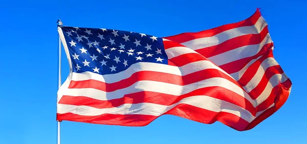 on Thanksgiving Day the flag of the United States of America flies with the wind of freedom in the blue sky and defends all American citizens