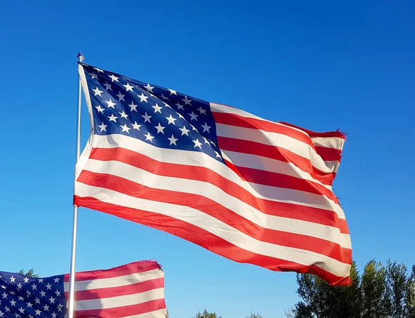 on Thanksgiving Day the flag of the United States of America flies with the wind of freedom in the blue sky and defends all American citizens