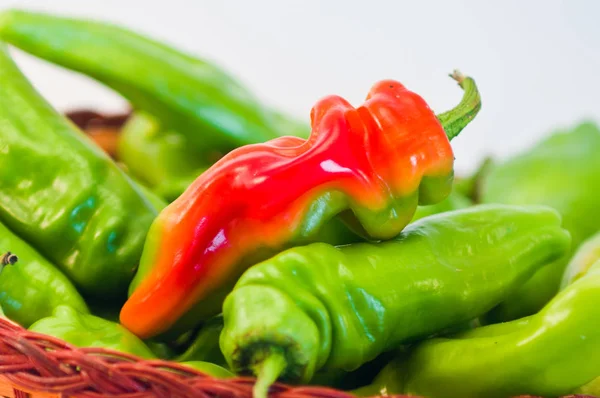 wicker basket full of sweet and spicy peppers, red and green, ready to flavor your dishes