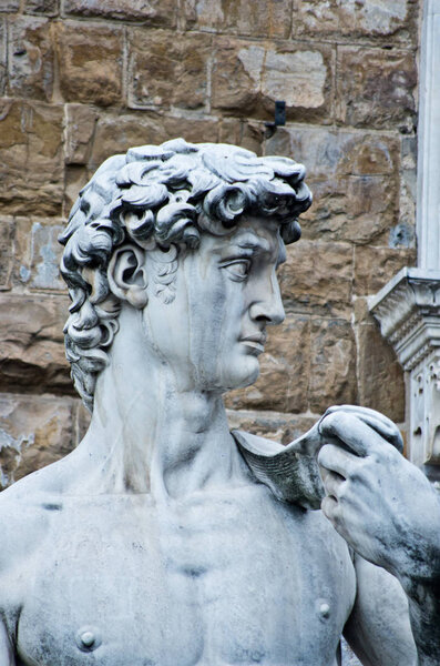 statue of david of michelangelo in florence with signs of the weather and decay in front of Palazzo Vecchio