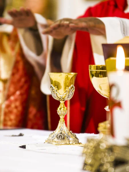 Mani del sacerdote consacrare vino e pane sull'altare di ho — Foto Stock