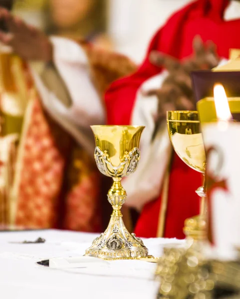 Mani del sacerdote consacrare vino e pane sull'altare di ho — Foto Stock