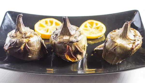 Cocina tradicional: alcachofas cocinadas en el horno con aceite y —  Fotos de Stock