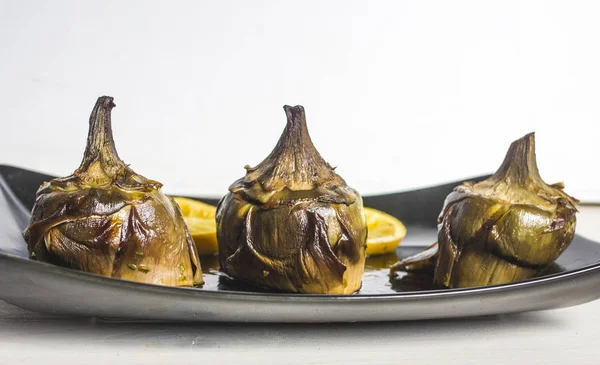 Cocina tradicional: alcachofas cocinadas en el horno con aceite y —  Fotos de Stock