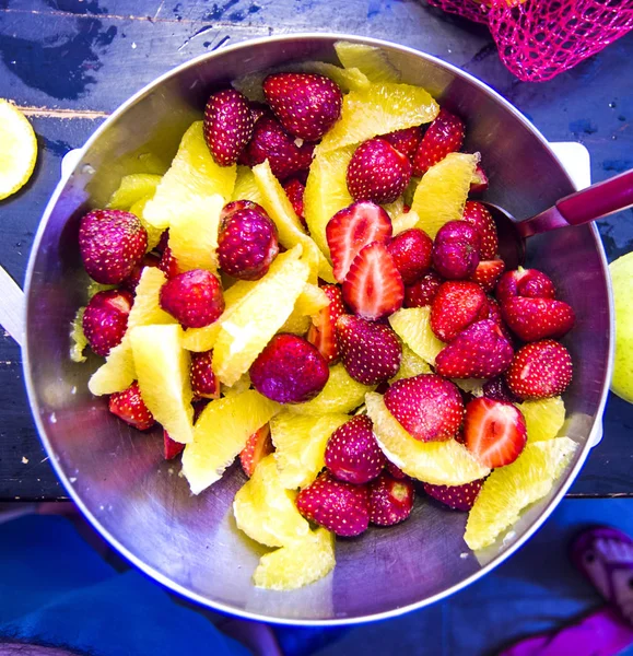 Skalade orange fruktsallad och mogna jordgubbar — Stockfoto