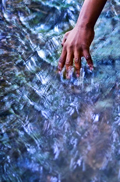 hand touching water, source of life