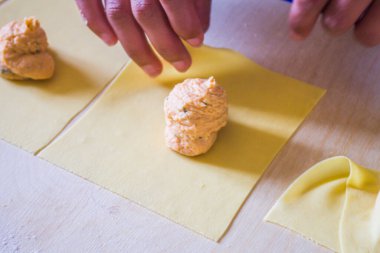 İtalyan ev hanımı yumurta makarna, ravioli ve tortelli hazırlıyor, somon dolması ile doldurulmuş, öğle yemeği için..