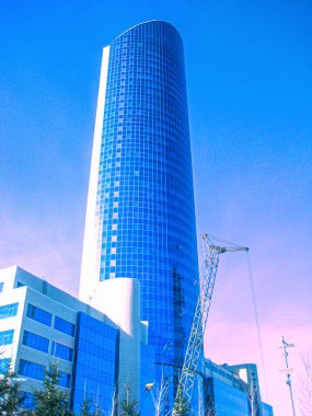 Günbatımı arka planında cam gökdelen. Mart 2010 'da Nur-Sultan' da şehrin yeni bir bölgesinde inşaat çalışması sürüyor..