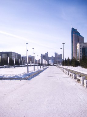 Şehirde beyaz kış. Modern binaları olan kar ve beyaz bir sokak. Bir gökdelen ve sokak lambaları görülebilir. Astana (Nur-Sultan), Kazakistan Jan 2011