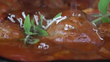 Domates soslu İtalyan köftesi rendelenmiş parmesan peynirli makro yakın plan.