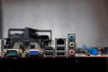 Kahverengi arkaplandaki iskele kartının yakın çekimi. USB, VGA, Ethernet, DVI, ses portları