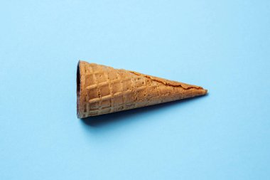 Kahverengi gözleme boynuzu içinde çikolatalı süzme peynir var ortada açık mavi arka planda, düz yatay olarak. Waffle tatlısını tazelemek, fikir konsepti, üst görünüm, kapat, boşluğu kopyala