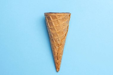 Kahverengi gözleme boynuzu. Ortasında çikolata jöleli süzme peynir var. Soluk mavi arka planda. Waffle tatlısını tazelemek, fikir konsepti, üst görünüm, kapat, boşluğu kopyala