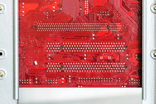 Red computer circuit board connected to the case. Hardware components. View inside, background, close-up