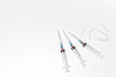 Beyaz arka planda izole edilmiş temiz ve kullanılmış şırınga ve ampuller. Tedavi ve tedavi arka planı, afiş, kopyalama alanı