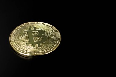Yansıması ve koyu siyah arkaplanı olan altın bir Bitcoin 'in yakın çekimi. Şifreli para birimi. BTC.