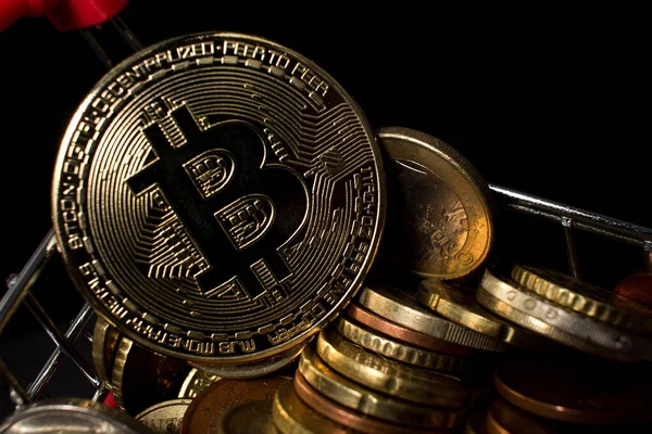 Bitcoin madeni parasının Euro bozukluklarıyla bir alışveriş arabasında yakınlaştırılması. Koyu arkaplanı olan BTC sikkesi.