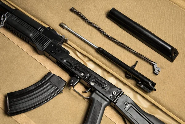 Parçalanmış bir saldırı tüfeğinin temel parçalarının üst görüntüsü. Rus Kalaşnikof MKK-104 (son model AK-47).