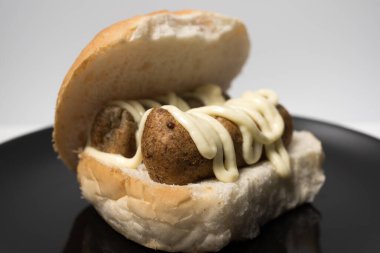 Hollanda usulü abur cubur broodje frikandel ile mayonez sosu. Hollanda 'da kızartılmış atıştırmalık. Frikandel beyaz bir topuz üzerinde.