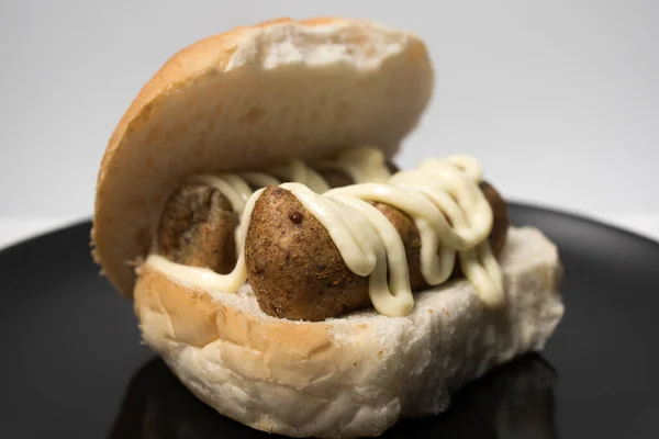 Hollanda usulü abur cubur broodje frikandel ile mayonez sosu. Hollanda 'da kızartılmış atıştırmalık. Frikandel beyaz bir topuz üzerinde.