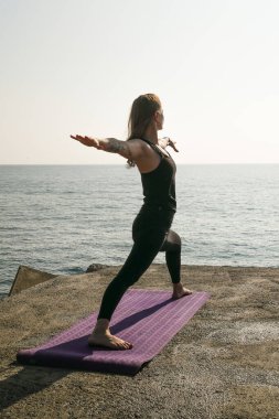 Barcelona 'da farklı yerlerde yoga pozisyonları ve rutinler yapan bir kız..