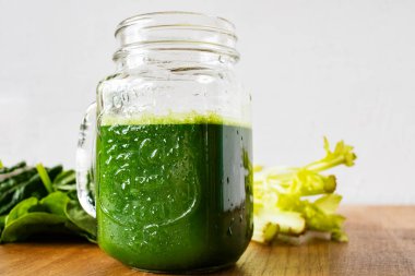 İçi yeşil meyve suyu dolu mason kavanozu kupaları. Büyük cam kavanoz ve taze yeşil meyve suyu..