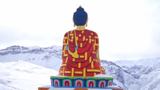 Zurück Ansicht der Langza Buddha-Statue mit einem verschneiten Berg im Hintergrund im Winter in der Nähe des Spiti-Tals in Langza, Himachal Pradesh, Indien. - Auszoomen Schuss — Stockvideo