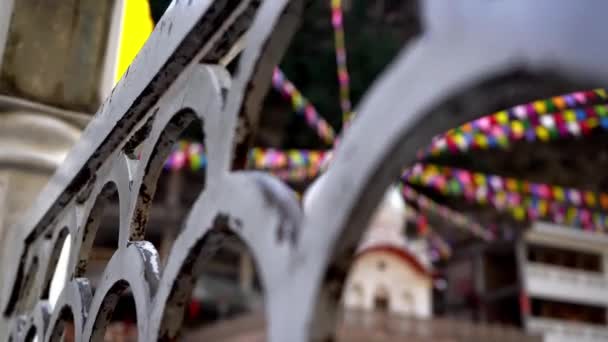 Bunte Gebetsfahnen um berühmte Gurudwara von Manikarna, die durch das Geländer des Tempels gerahmt sind — Stockvideo