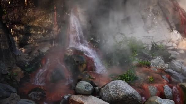 Acqua fumosa bollente calda naturale che scorre giù su pietre rosse mostrando la natura miracolo e meraviglie — Video Stock