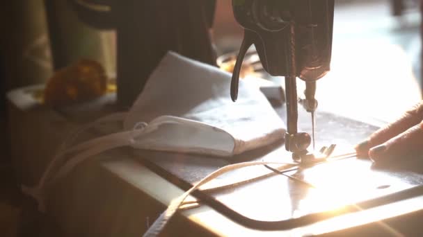在印度阿格拉市的手工缝纫机上，一个女人的手在手工缝纫机上用白色织物缝制的自制可重复使用的布面面具。-特写镜头 — 图库视频影像