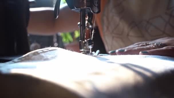インドのアグラ市にある伝統的な手動ミシンで、女性は下に曲がり、布の端を縫う。-ショットを閉じる — ストック動画