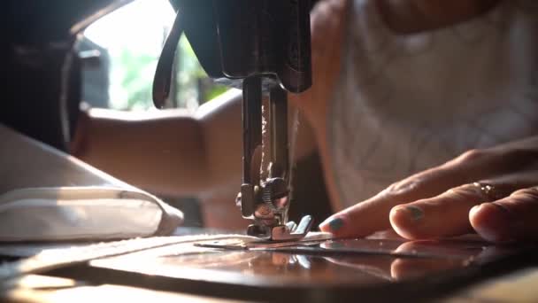 Hand van vrouw naaien een strook witte katoenen doek voor het maken van gezichtsmasker met behulp van handmatige naaimachine in een winkel in Agra, Uttar Pradesh, India, Close-up schot — Stockvideo