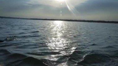 Hindistan 'ın Uttar Pradesh eyaletinin Varanasi şehrindeki Ganj Nehri' nin suyunda gün doğumunda kürek çeken kişi. - Yakın çekim.