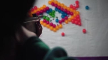 İtme deve fuarında bir kızın hava tabancasıyla balon patlatırkenki görüntüsü.