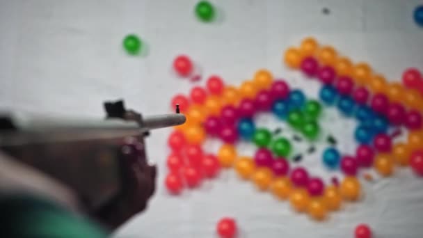 Tiro cinematográfico de uma menina estourando um balão com uma arma de ar na feira de camelos pushkar — Vídeo de Stock