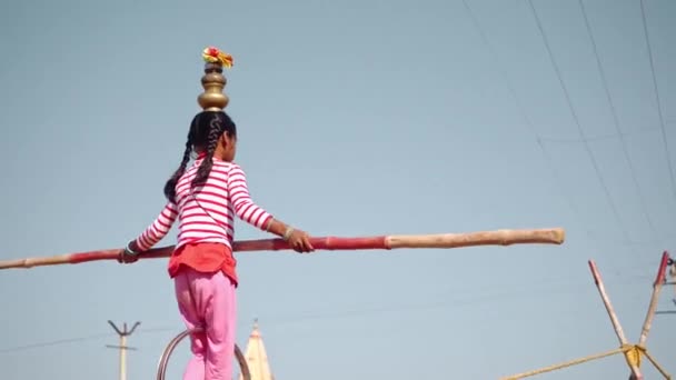 Interessantes Video von Mädchen, die auf einem Seil hüpfen, während sie auf einem Stuhl stehen, der Gewicht auf ihrem Kopf in der Kamelmesse Pushkar hält — Stockvideo