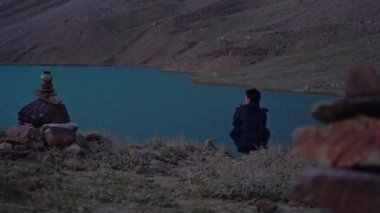 Güzel bir çerçevede oturan ve güzel bir Himalaya gölünde resim çeken bir adam, spiti vadisi.