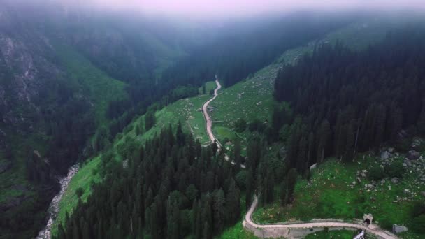 Letecký záběr na silnici, která se rozbíhá do hor během monzunu obklopeného mraky v Manali, Himachal Pradesh, postupující vpřed — Stock video