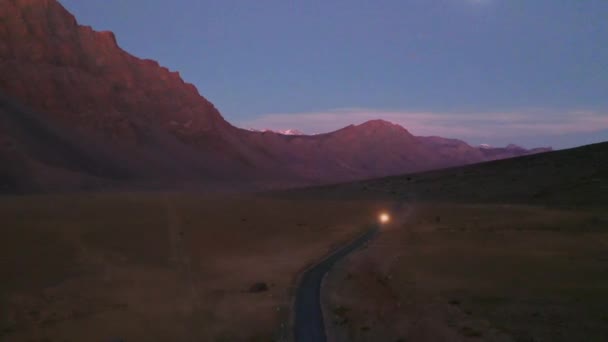 Luchtfoto van een auto gaat op een rechte himalaya weg met lichten aan in de schemering, Going Upwards — Stockvideo