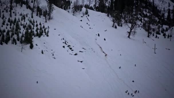 Vista aérea de dos personas tratando de subir una montaña nevada en Solang, Himachal, acercar — Vídeo de stock