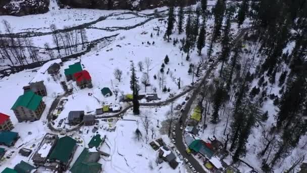 Luftaufnahme von ein paar himalayischen Hütten, die rundum mit Schnee bedeckt sind im Dorf Solang, Manali, Wide Reverse — Stockvideo