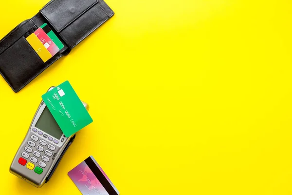 Payment by credit card. Terminal on yellow background top-down copy space