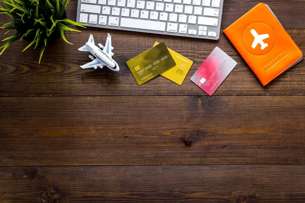 Flight booking - passport, cards, computer keyboard - on wooden background top view copy space